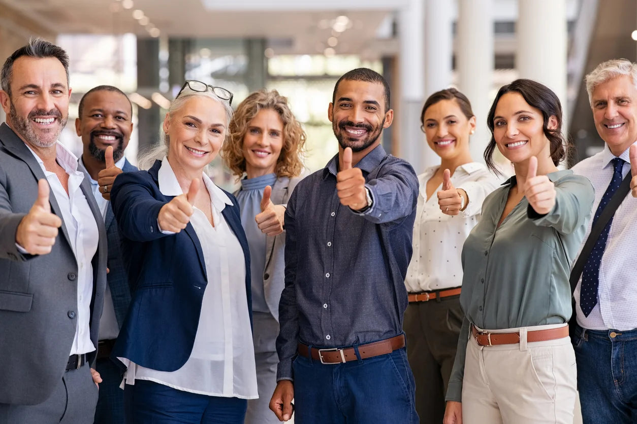 Diverse team of professionals giving thumbs up after completing corporate training program